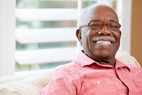 Close up of African American man smiling wearing glasses and a red shirt