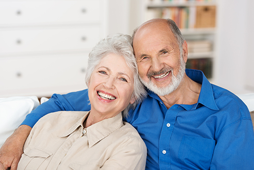 Smiling couple sitting closely on couch